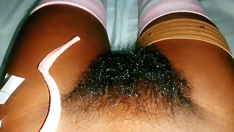 Hairy indian girl shows off her hairy pussy on a bed